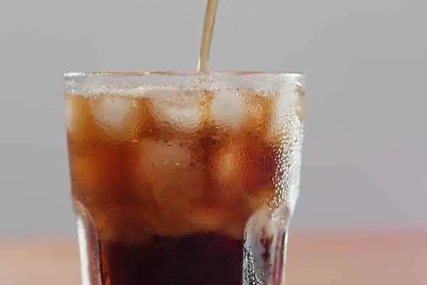 picture of coca cola in a glass with a straw